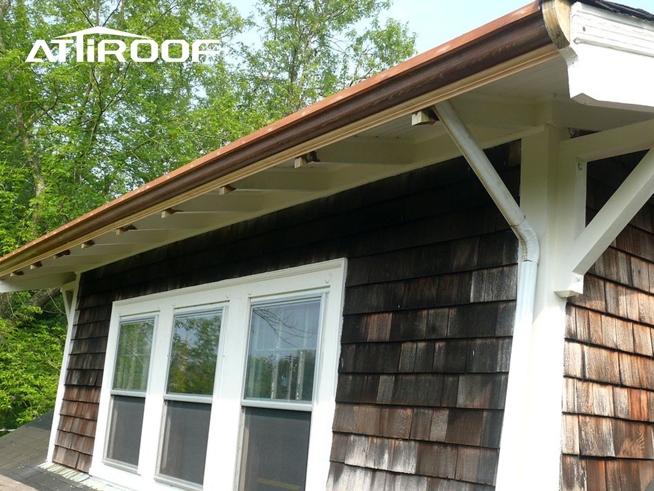 A real-life picture of a rustic style cottage equipped with a wooden drainage system.