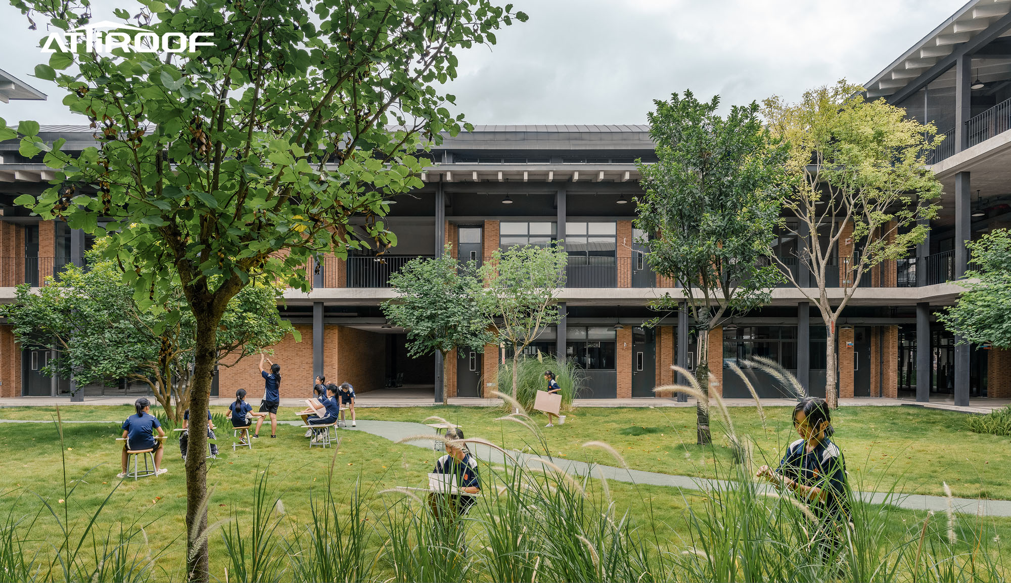 Image of students and teachers enjoying outdoor activities under a new roof at a school.